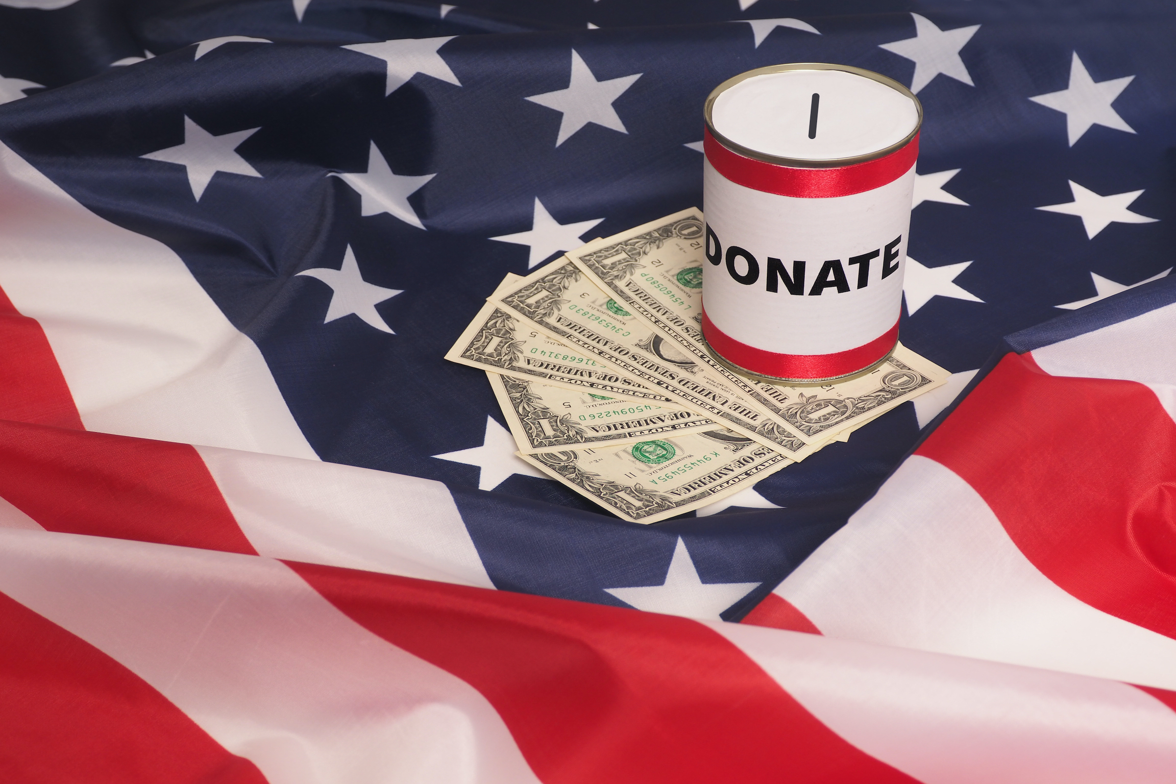 Money on USA flag with donation can.